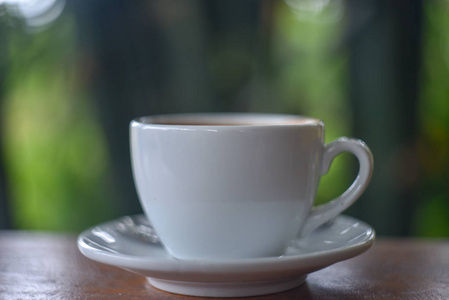 咖啡杯。 在木制背景的白色杯子里喝杯咖啡