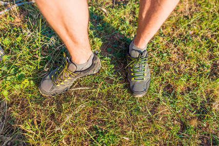 s legs on the grass. The limbs of a man in gray sneakers. Yellow