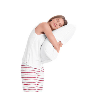 穿着睡衣抱着白色背景枕头的年轻女子