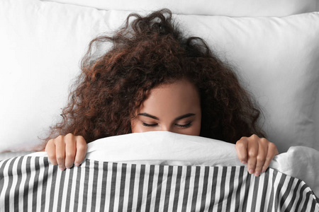年轻的非裔美国妇女睡在柔软的枕头上。 睡觉