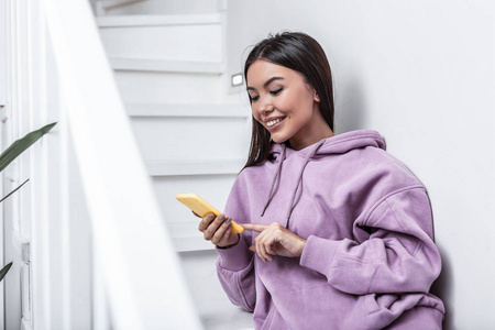 黑头发的女人拿着黄色智能手机, 同时阅读消息