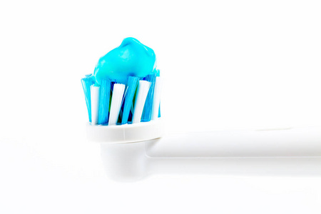 电动牙刷头隔离在白色背景特写。 牙膏的侧视图。