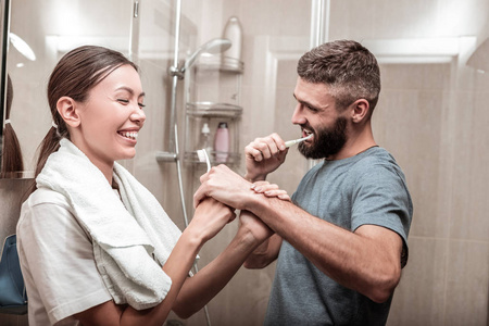 年轻的情侣有很多的乐趣, 而刷牙在一起照片