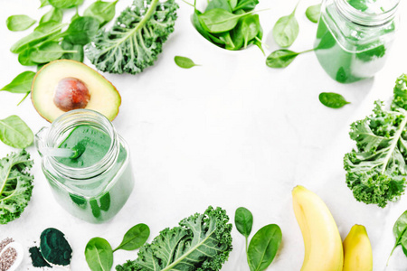 新鲜健康的绿色冰沙，放在白色桌子上的罐子里