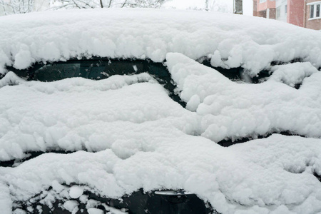 汽车上覆盖着厚厚的一层雪。 大雪的负面后果。