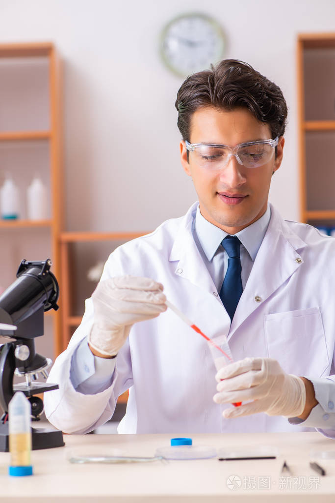 年轻英俊的生物化学家在实验室工作