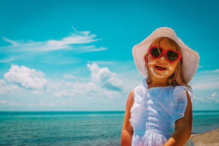 防晒快乐的小女孩与防晒霜在海滩