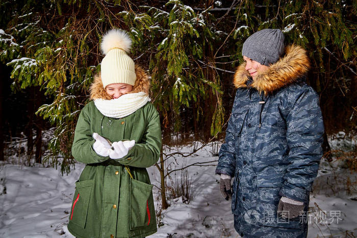 一个冬天男孩和女孩在雪林里散步青少年周末在户外休息在寒冷的天气里
