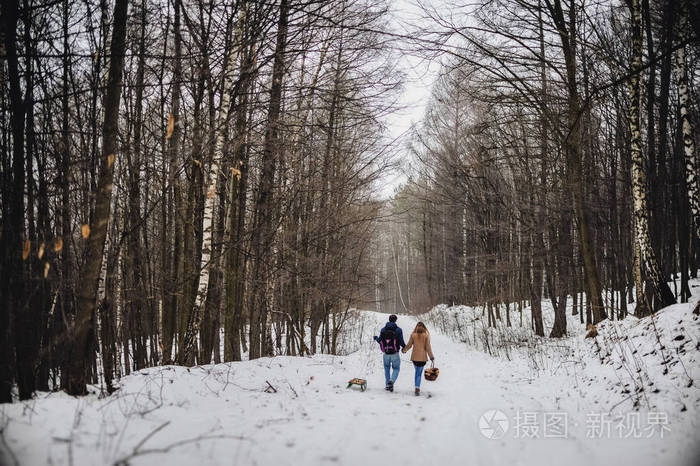 快乐的一对情侣在雪地冬季公园玩得开心