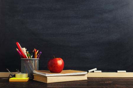 s desk with writing materials, a book and an apple, a blank for 