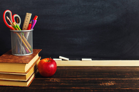 s desk with writing materials, a book and an apple, a blank for 