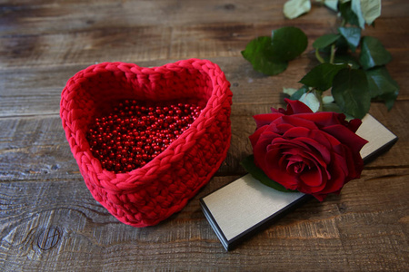 红色玫瑰，有一个心形的篮子和一个木制乡村背景上的礼物盒子