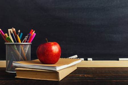 s desk with writing materials, a book and an apple, a blank for 