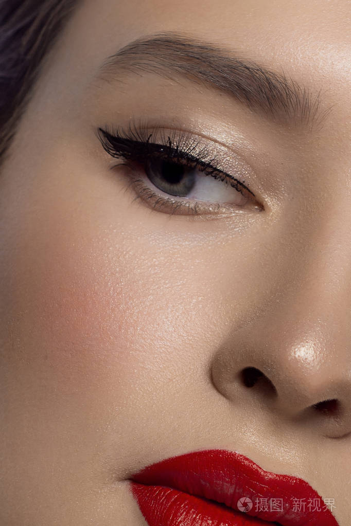 眼睛上的黑色箭头和丰满的嘴唇上极长的睫毛,光滑的猩红色唇色.