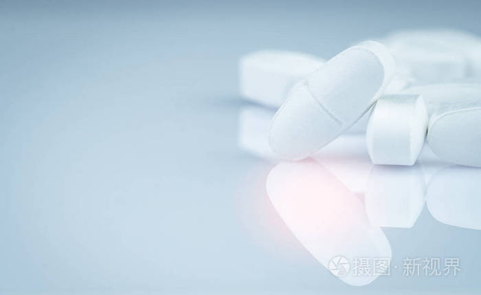 灰色背景上的一堆白色长方形药片. 制药业. 药房产品. 止痛药. 钙片.