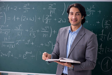 年轻的英俊数学老师在教室里照片