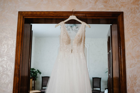 时尚经典蕾丝丝绸新娘礼服挂在房间衣架上