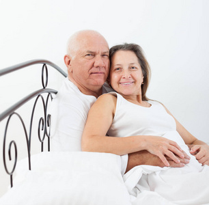 年长的男人和女人躺在床上拥抱。