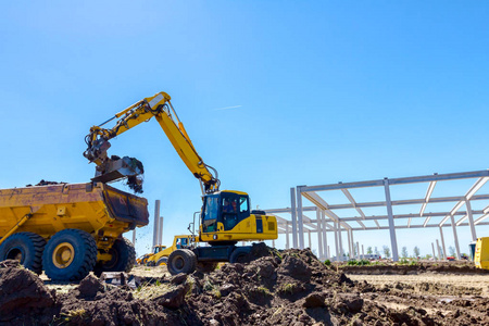 大挖掘机正在施工现场工程中用土填充翻斗车。