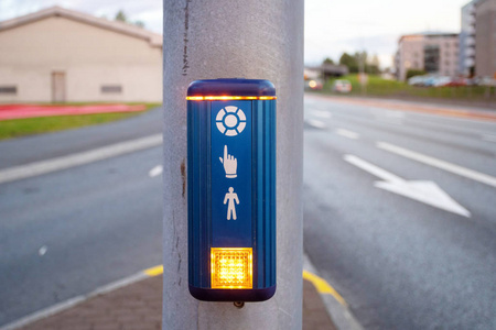 按下按钮，准备过马路。 带小型行人的蓝色交通灯照片