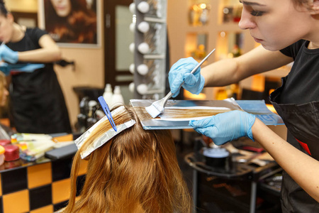 美发染发专业美发师在发廊染发她的客户选择性焦点照片