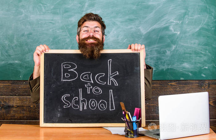老师或学校校长欢迎用黑板题词回到学校。欢迎回来。9月新学年开始。老师欢迎新生进入教育机构