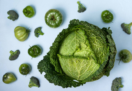 绿色蔬菜背景蓝色背景下的野菜花椰菜绿色西红柿。 上文视