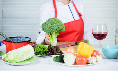 西兰花营养价值。生食饮食。女性专业厨师手持生花椰菜蔬菜。免费健康的素食和素食食谱。把花椰菜变成最受欢迎的食材。如何煮花椰菜