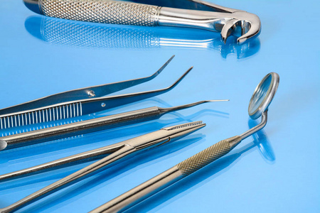 蓝色玻璃桌上的牙科工具牙科镜Kornzange探险家钳子和拔牙钳。牙科卫生，保健理念..