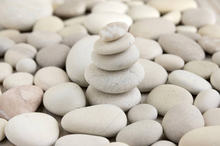 和谐与平衡，凯恩，在卵石背景上挖掘石头，岩石禅宗雕塑，白色和浅灰色卵石