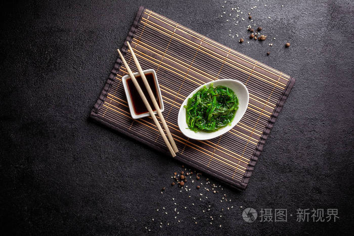 酱油和中国棍子在黑色的背景上.俯视,平躺