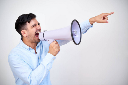 一个男人对着扩音器吼叫并在白色背景下指向方向的肖像照片