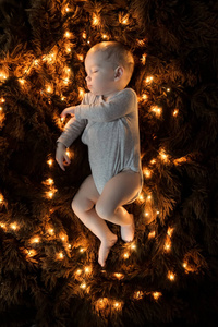 婴儿睡在毛茸茸的棕色毯子上，灯在他周围散开。