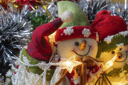 装饰好的圣诞树。 带有灯光花环的雪人玩具