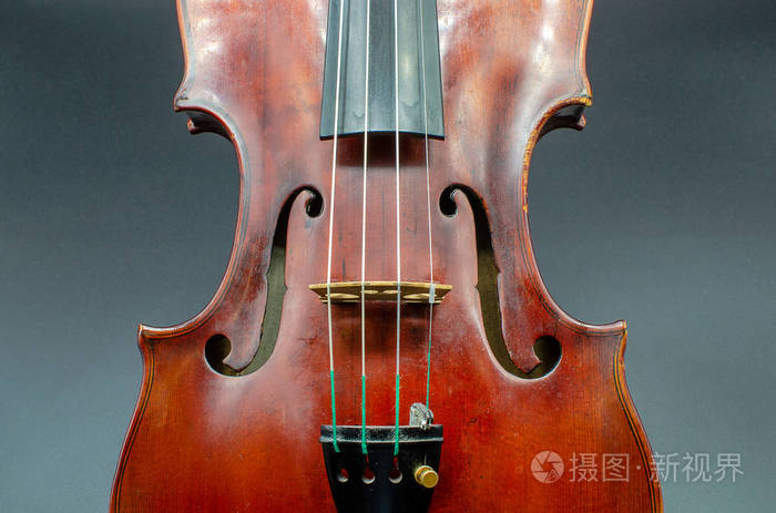 专业小提琴,可以看到腰部,重点放在f孔和桥上,在一个灰色背景的工作室
