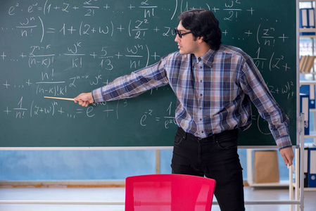 年轻有趣的数学老师在黑板前