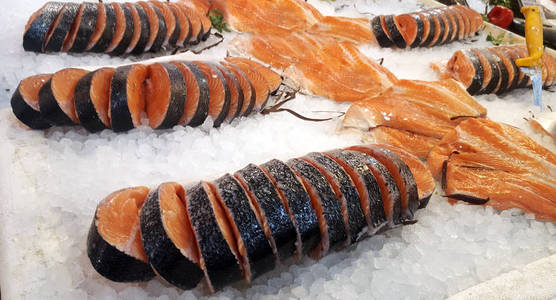 新鲜的鲑鱼片放在鱼市的冰上