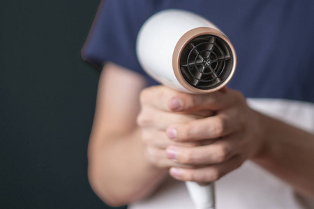 抓着女人头发干人拿着白色的吹风机在他的手隔离 b照片