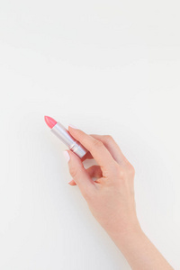 女性手与粘贴指甲油，持有粉红色口红隔离在白色背景与复制空间。 女性美容博客社交媒体模板