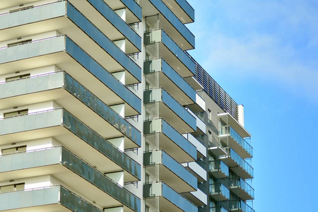 现代公寓楼在阳光明媚的日子里有一片蓝天。 现代公寓楼的正面