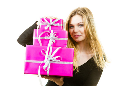 快乐的实证年轻的十几岁的女人拿着一大堆粉红色的礼盒。 女性收到许多礼物。