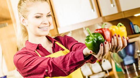 有趣快乐的女人拿着胡椒，美味健康的节食蔬菜，呈现饮食食物。