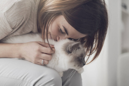 女人抱着漂亮的猫在她的大腿宠物和生活方式的概念