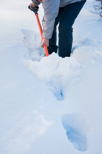清除积雪。 降雪后用铲子清理雪的人。 户外。