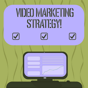 显示视频营销策略的书写笔记。展示引人入胜的视频的商业照片安装在桌面空白彩色文本框上的线图上的计算机屏幕