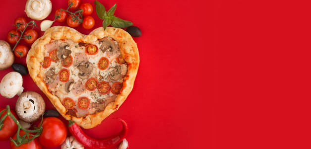 披萨心形，火腿西红柿和蘑菇在红色背景。 情人节浪漫爱情的概念。 爱食物