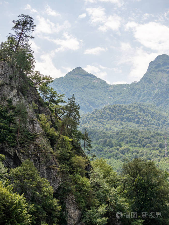 在阴天高山的山坡和山峰长满了绿林