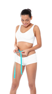 苗条的女人在白色背景上测量她的腰部。 重量损失