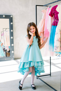 那个可爱的小女孩穿着一件漂亮的蓝色连衣裙。
