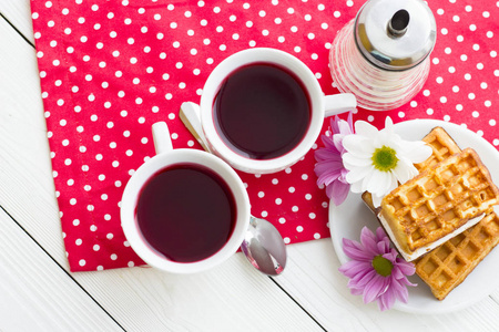 红茶仪式一杯茶，茶壶，糖，蛋糕，红色的花，白点背景，顶部视图，特写